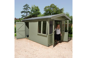 a green summerhouse with a lady standing in the open door way and a rear shed area with door open